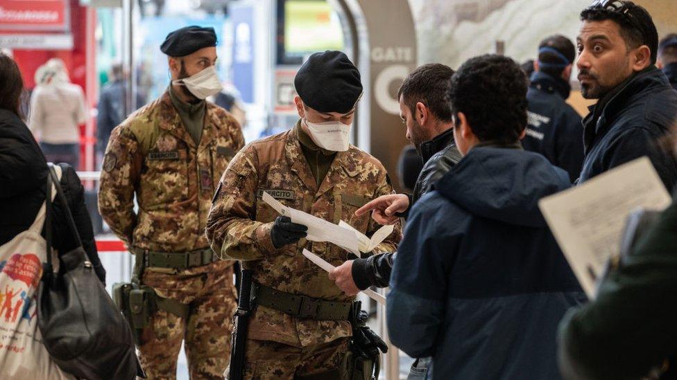 Italian authorities check passengers' documents at the Milan train station