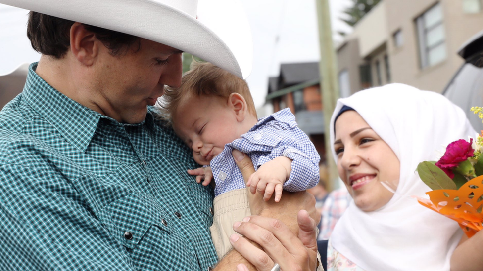 Canada PM Justin Trudeau (left) holds Justin Trudeau Adam Bilan