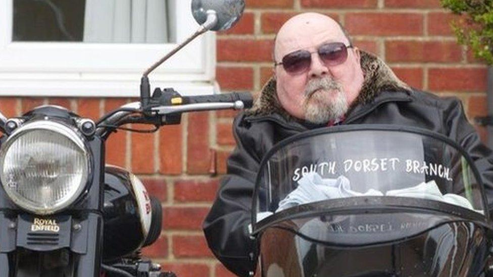 Joe Canning wearing sunglasses and sitting in a black motorcycle sidecar