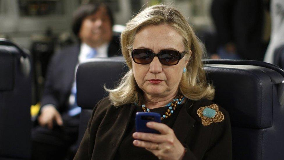 Then-Secretary of State Hillary Rodham Clinton checks her Blackberry from a desk inside a C-17 military plane upon her departure from Malta, 18 October 2011