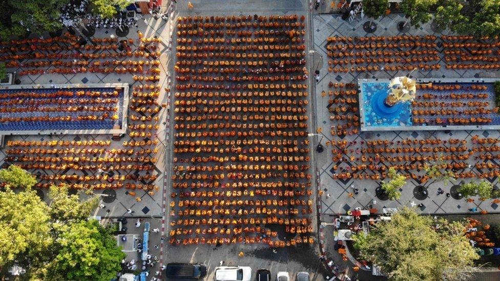 Buddhist monks gather for a mass prayer one week after a lone soldier shot and killed 29 people in Thailand