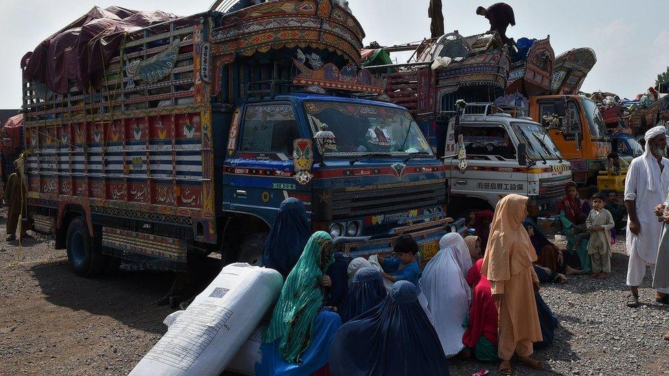 Afghan refugee families wait to board trucks at the United Nations High Commissioner for Refugees (UNHCR) repatriation centre on the outskirts of Peshawar on July 28, 2016,