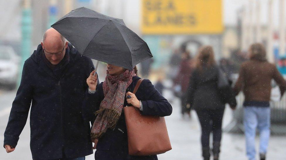 A couple under an umbrella in Brighton