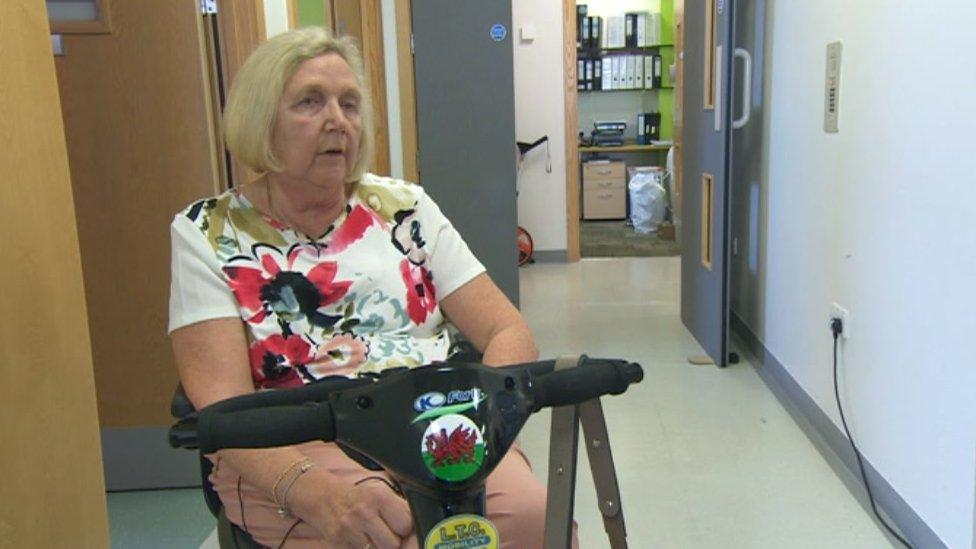 Patient Euryl James sitting on a mobility scooter in a hospital corridor