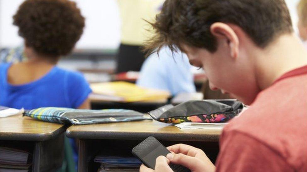 boy on mobile phone in the classroom