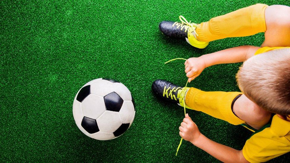 Boy and football on artificial turf