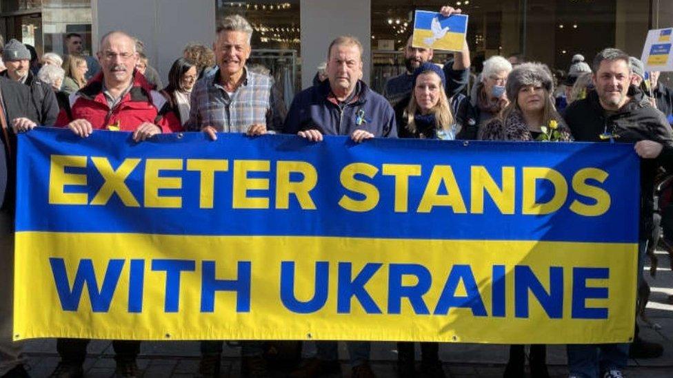 People holding up a banner at a vigil in Exeter in support of Ukraine