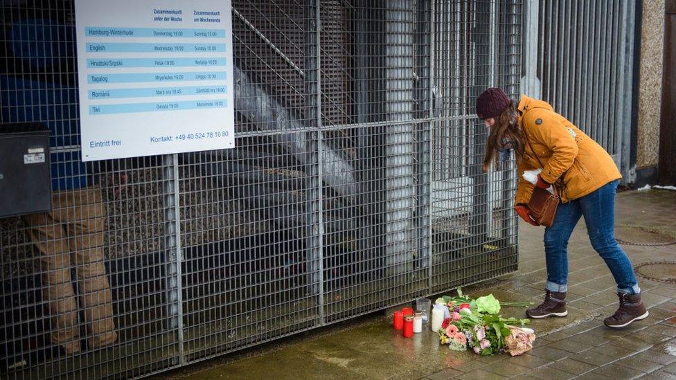 People put down flowers in front of the building where the attack happened