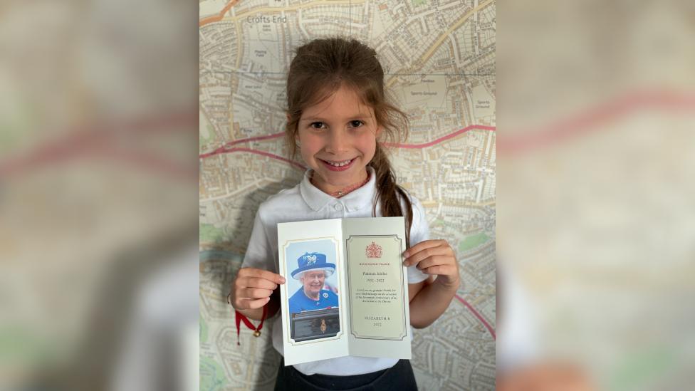 Young girl holding card from the queen