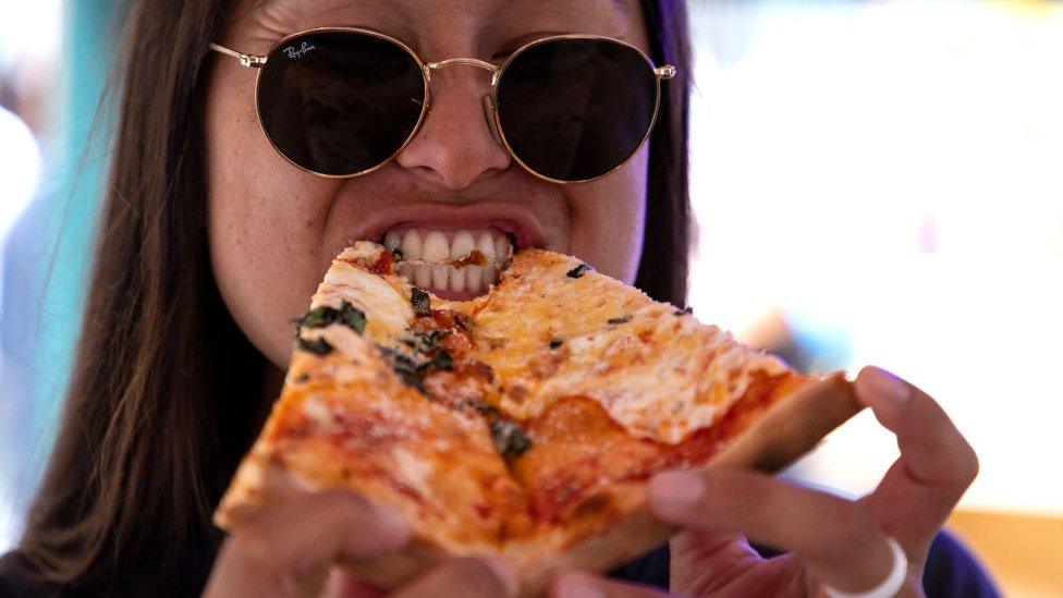 A New Yorker tucks into a slice