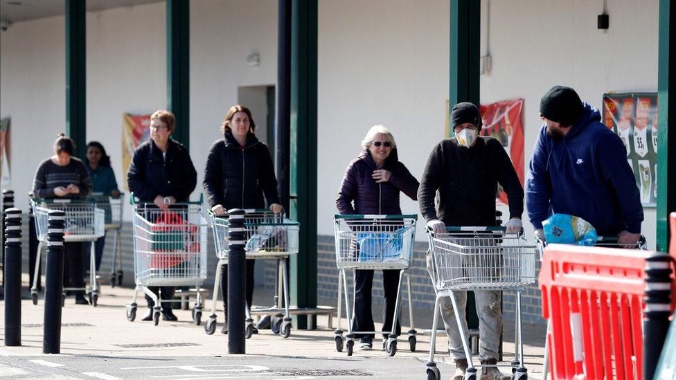 Shoppers observe social distancing as they wait in a queue outside a supermarket in Fleet, Hampshire on March 28, 2020. - The two men leading Britain"s fight against the coronavirus - Prime Minister Boris Johnson and his Health Secretary Matt Hancock - both announced Friday they had tested positive for COVID-19, as infection rates accelerated and daily death rate rose sharply.