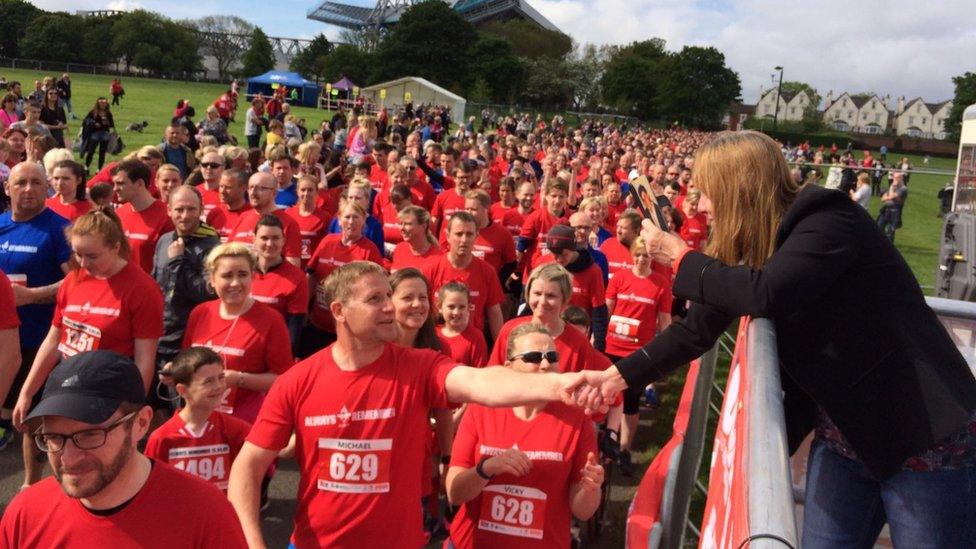 Runners shake the hand of Margaret Aspinall