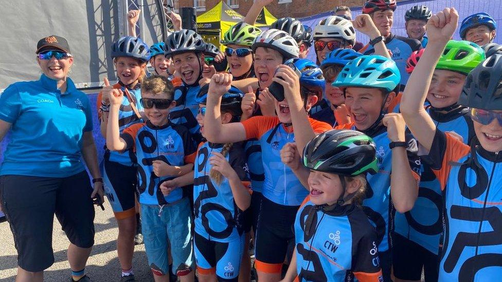 Kids wearing cycle gear and cheering