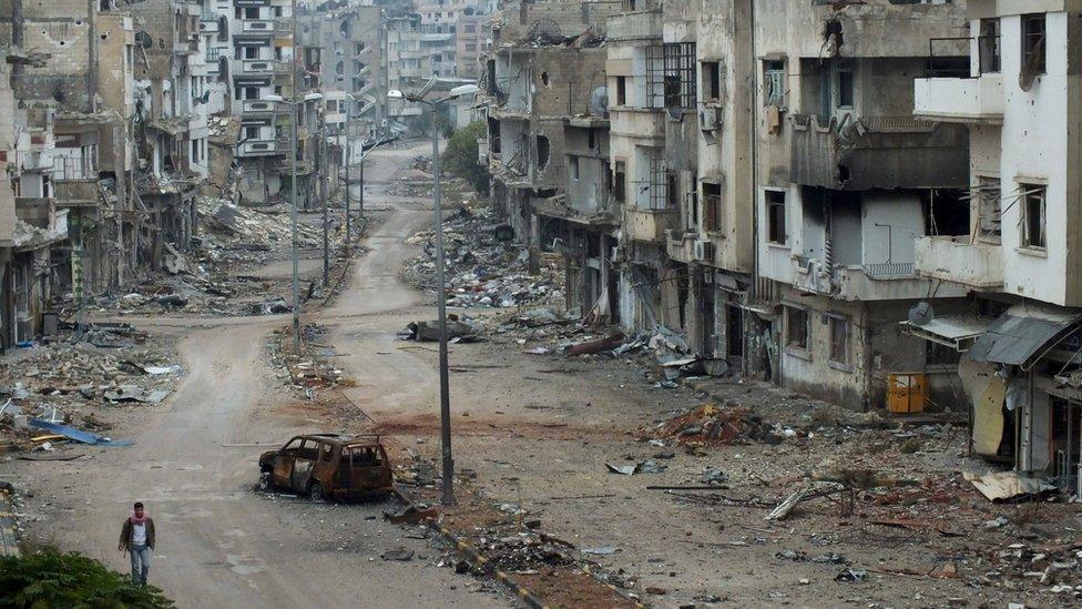 Burnt car and damaged buildings along a street at the al-Khalidiya neighbourhood of Homs, Syria on 19 November 2012