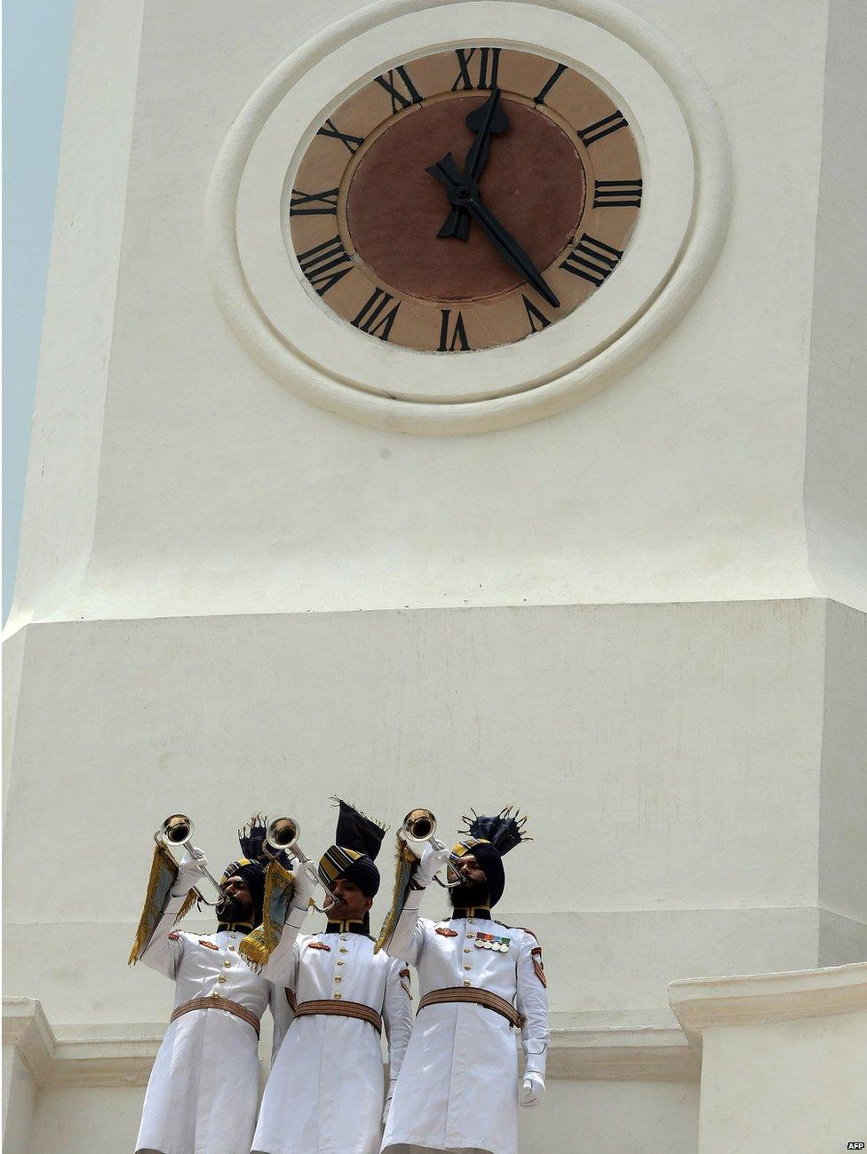 Indian President's ceremonial guards blow trumpets during the inauguration by President Pranab Mukherjee of a restored clock tower inside The President's Estate in New Delhi on 24 July 2015, to mark the completion of the third year of his presidency.