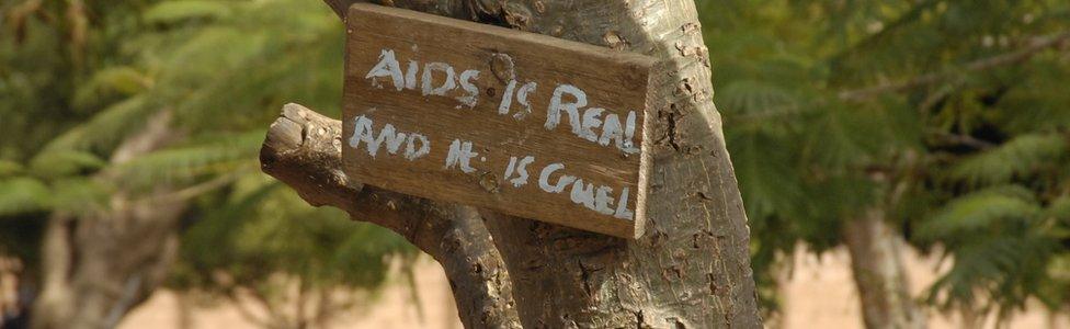 A sign in Zambia attached to a tree reading: "Aids is real and it is cruel"