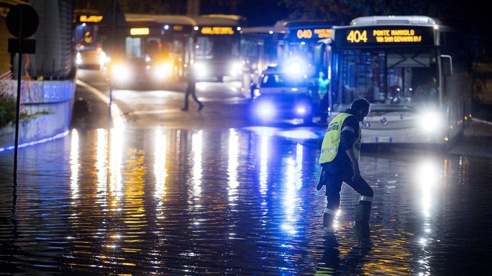 An Italian policeman works in a flooding street in Rome