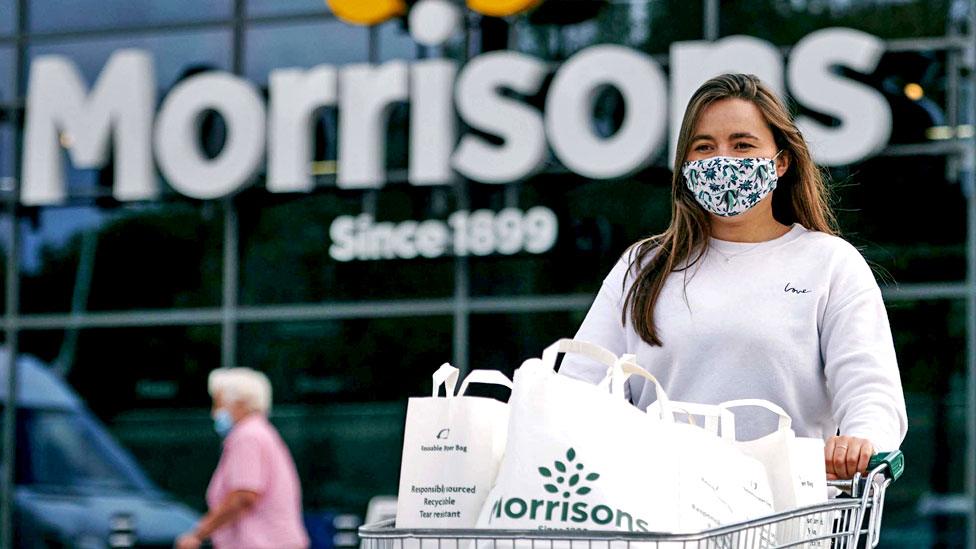 A woman with a supermarket trolley outside Morrisons