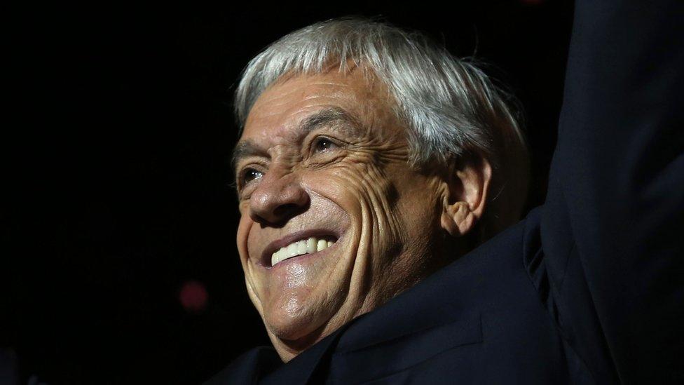 Sebastian Piñera in close-up, seen from slightly below, as he waves and smiles to a crowd in December 2017