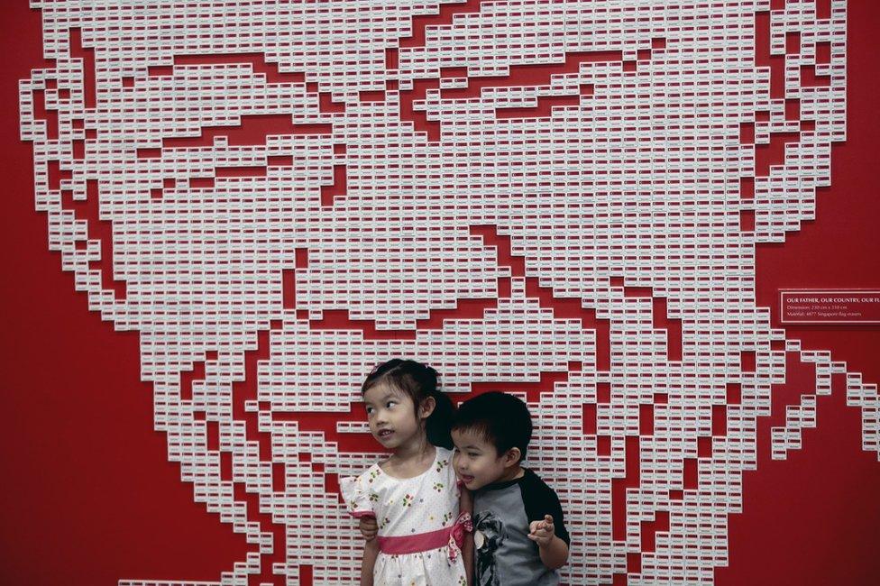 Two young children pose for a photograph against a mural made out of nearly 5,000 Singapore country erasers forming the likeness of Mr Lee Kuan Yew, during a tribute event in Singapore, 20 March 2016.