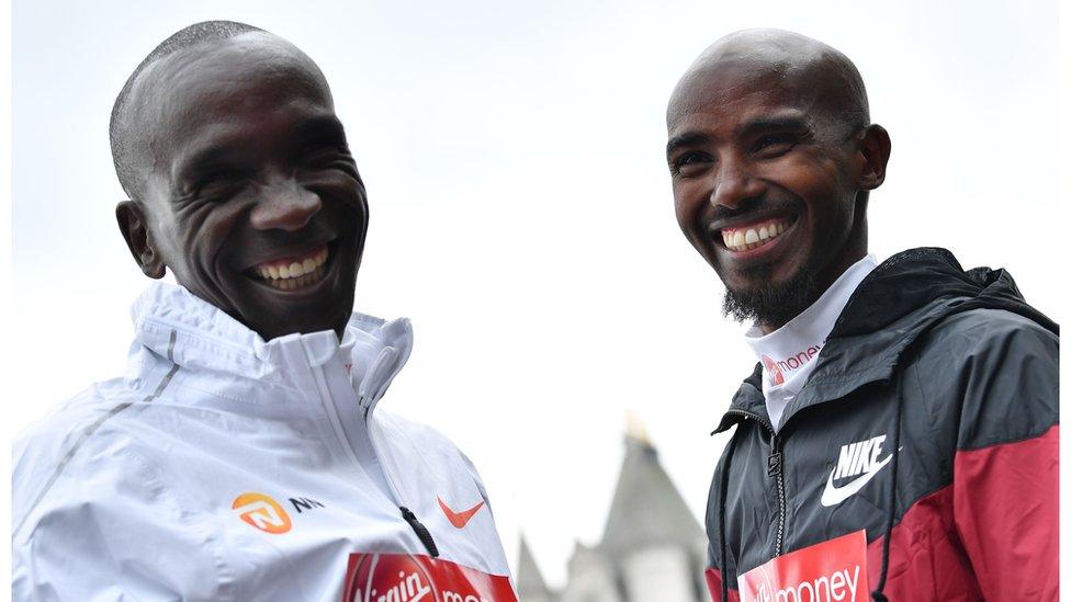 Kenya's Eliud Kipchoge (L) and Britain's Mo Farah pose during a photocall for the London marathon at Tower Bridge in central London on April 24, 201