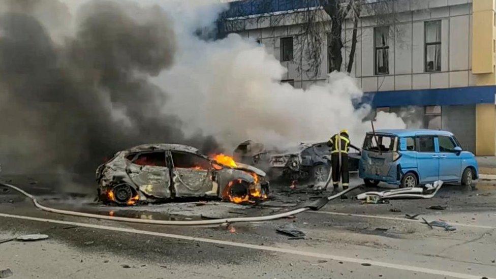 Russian firefighters extinguishing burning cars after shelling in Belgorod, Russia, 30 December 2023