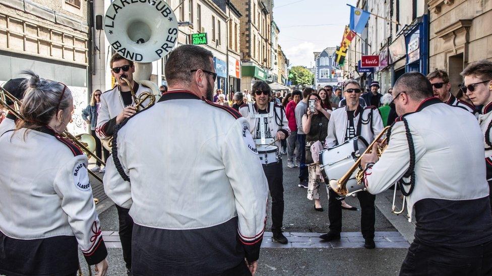 Band Pres Llareggub yn diddanu ar Stryd Llyn ac yn chwarae 'Ysbeidiau Heulog'. Mi wrandawodd yr haul arnynt drwy'r dydd