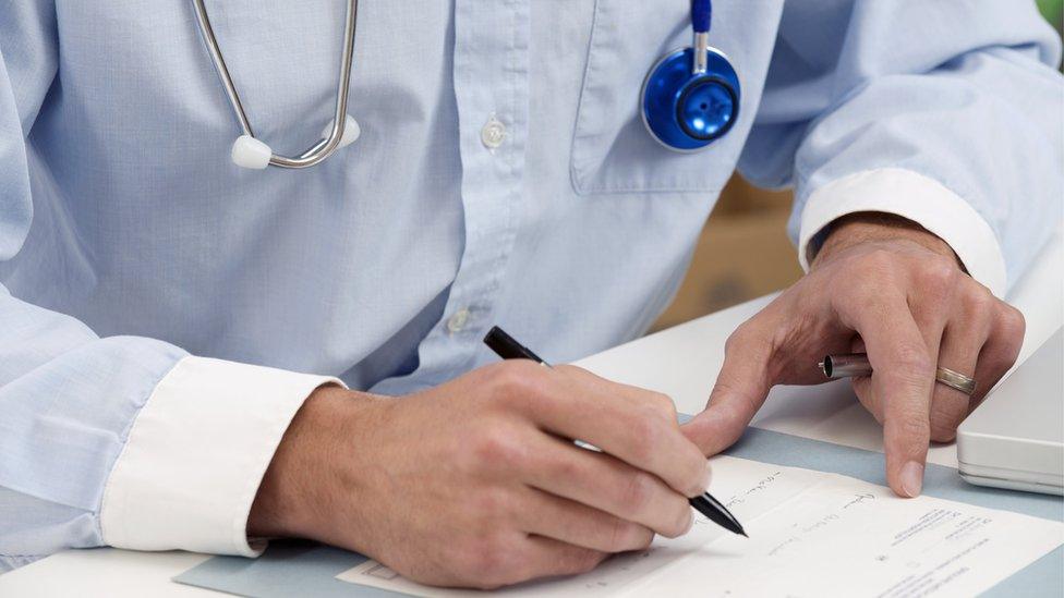 Doctor writing notes at his desk