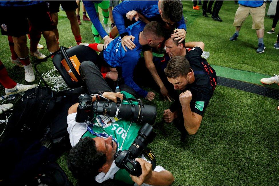 Croatia players celebrate next to an AFP photographer Yuri Cortez after Mario Mandzukic scores their second goal