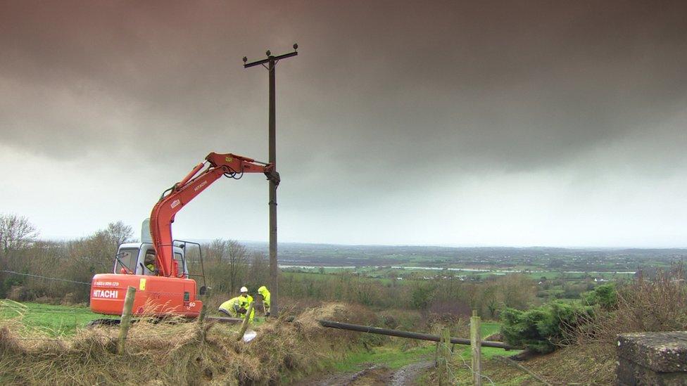 NIE Networks staff work to repair a electricity pole on a country road