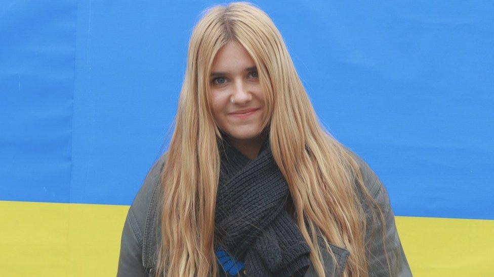 Ella Lambert in Poland in front of a Ukraine flag