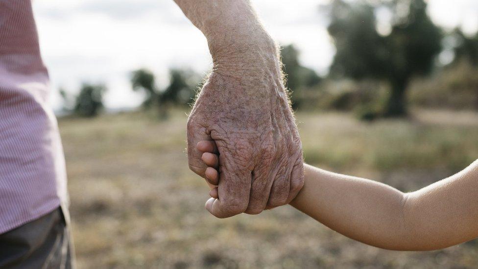 Grandparent holding hands with child