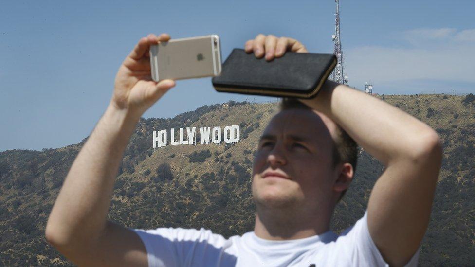 A tourist enjoys the view of the Hollywood sign