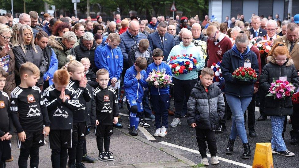 Members of the community take part in a minute's silence during an event to mark the 30th anniversary of the Shankill bomb.