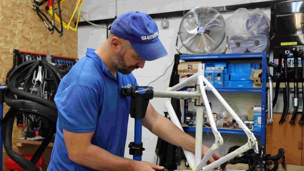 A staff member repairs a bike at the charity