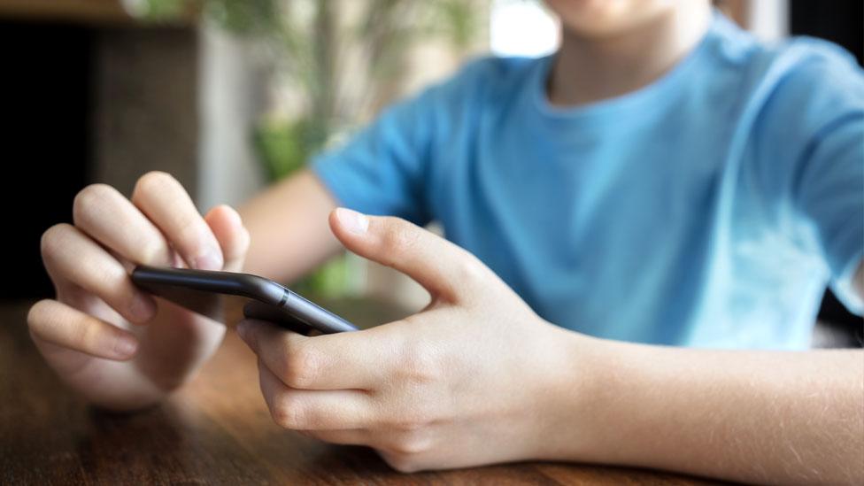 Stock image of a child on a mobile phone