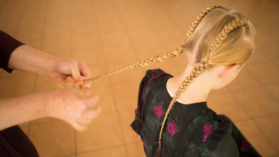 Mennonite girl has her hair plaited