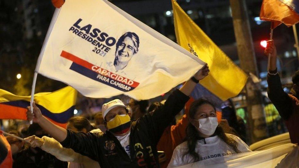 Supporters of Presidential candidate Guillermo Lasso wave flags as they await the official results of the presidential election, in Quito, Ecuador 11 April 2021