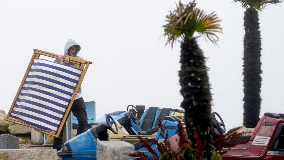 Man clearing away deckchair