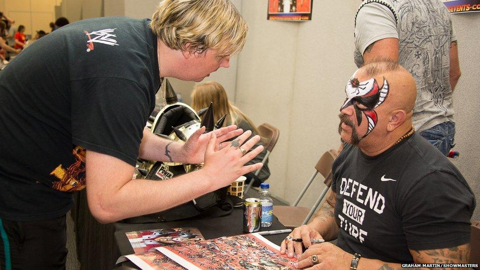 Wrestler signing an autograph for a fan