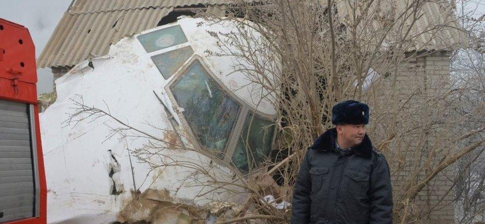 A policeman in front of a Boeing 747 which landed on houses outside Bishkek, Kyrgyzstan (16 Jan 2016)