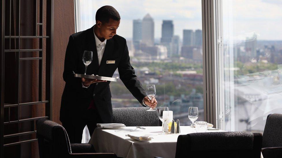 A waiter prepares a table