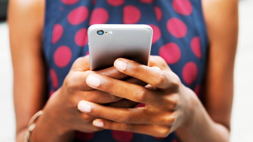 Stock image of a person's hands holding a smartphone