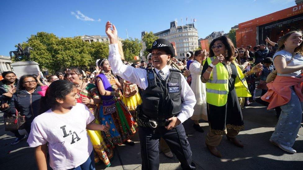 Police officer dances with people at Diwali celebration Trafalgar Square