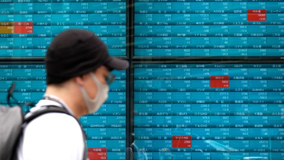 Man walking past market board.