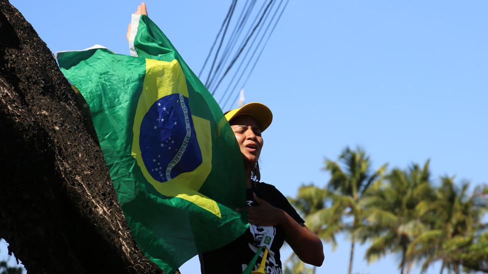 A supporter of Jair Bolsonaro waves a flag