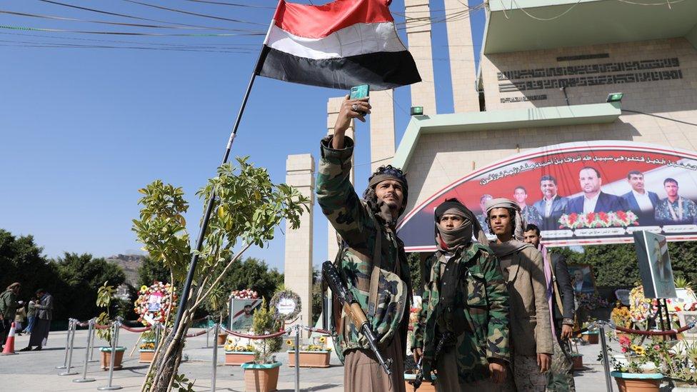 Members of the Houthi movement take a selfie near the grave of a senior Houthi official in al-Sabeen Square in Sanaa, Yemen (11 January 2021)