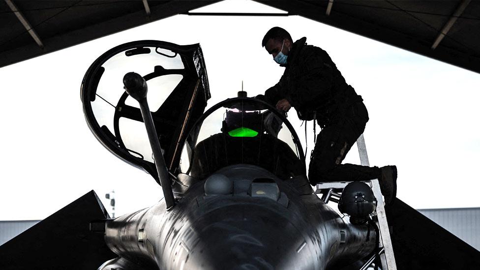 A French fighter jet pilot inspects his aircraft prior to taking off for a daily Nato border watch mission over Poland