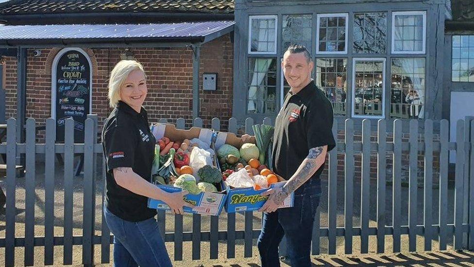 Trina Lake and Bradley Richards with boxes of fruit and vegetables