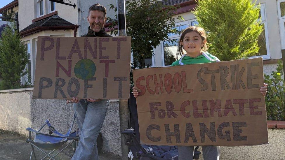 School climate striker with adult and 2 signs